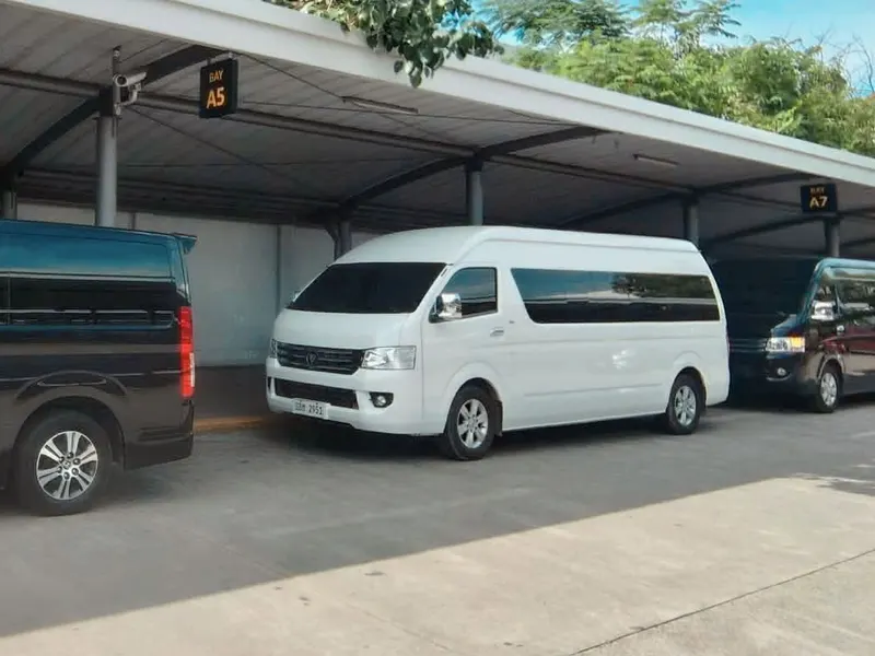 White tourist van parked under a covered parking area